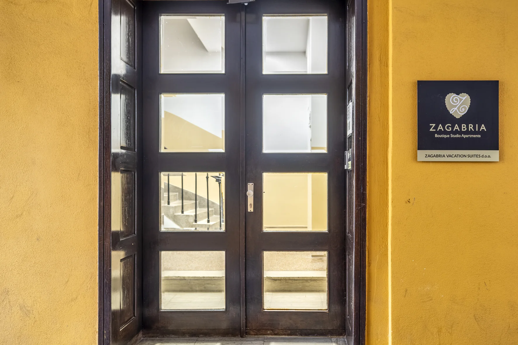 Ulazna vrata zgrade u Ilici 10 s pločom Zagabria Boutique Studio Apartments